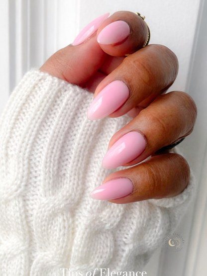 Hand with pink nail polish holding a white textured fabric