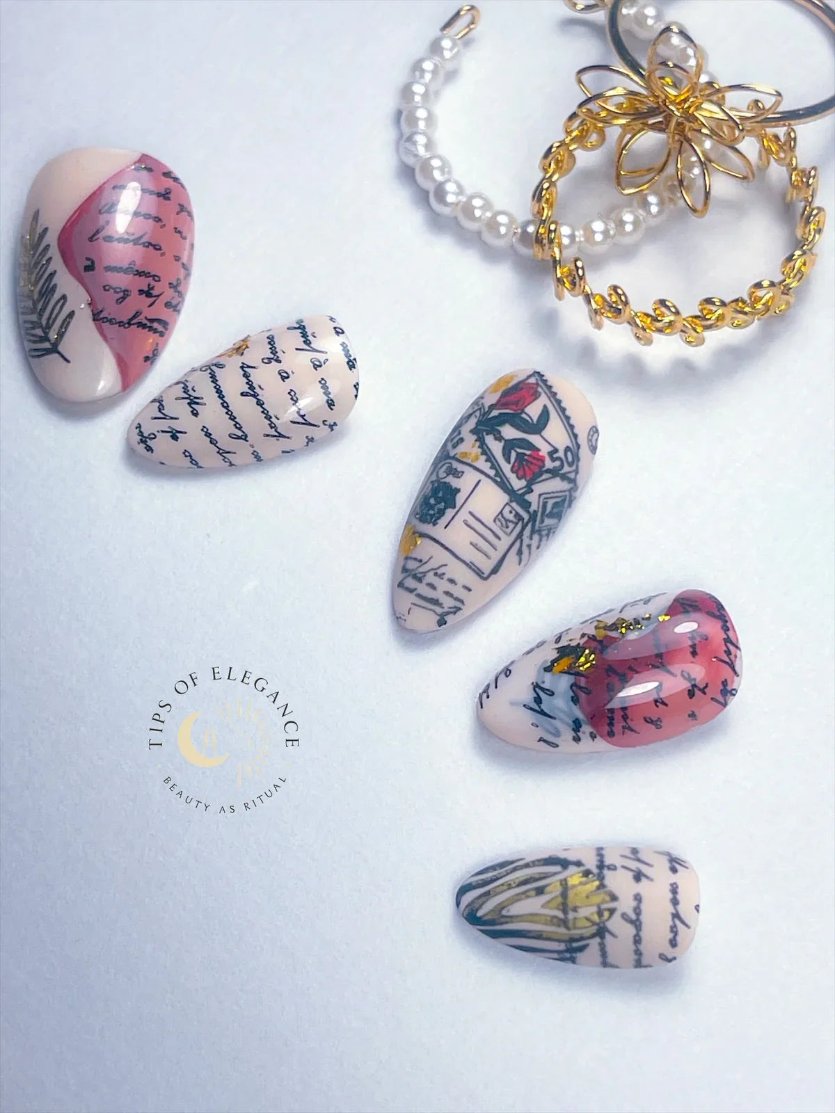 Nail art with vintage book page design and keychain on a light background