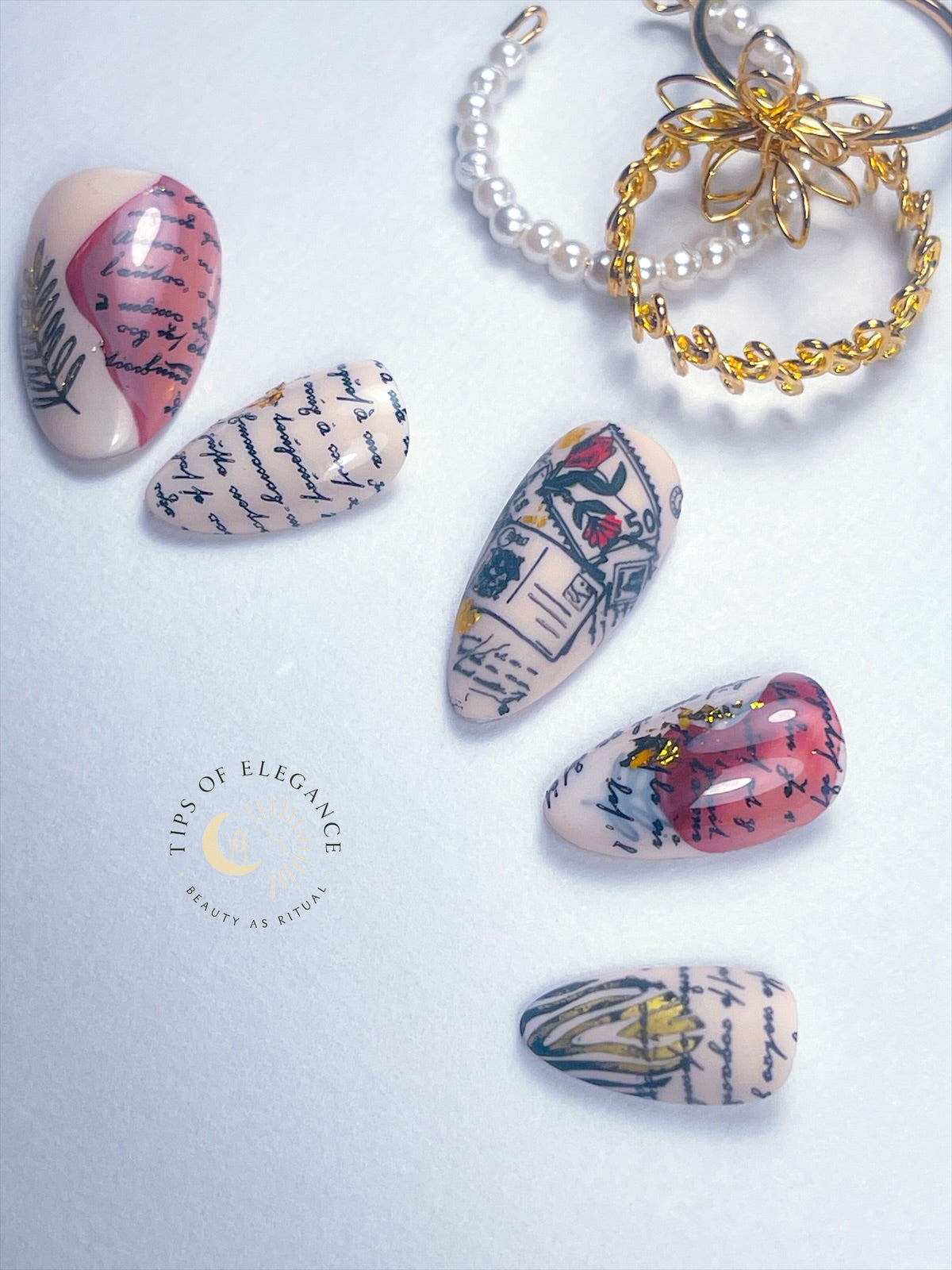 Nail art with vintage book page design and keychain on a light background