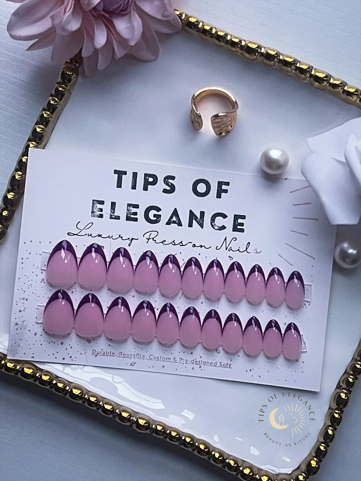 Pink and purple nail art tips on a 'Tips of Elegance' card with decorative elements.