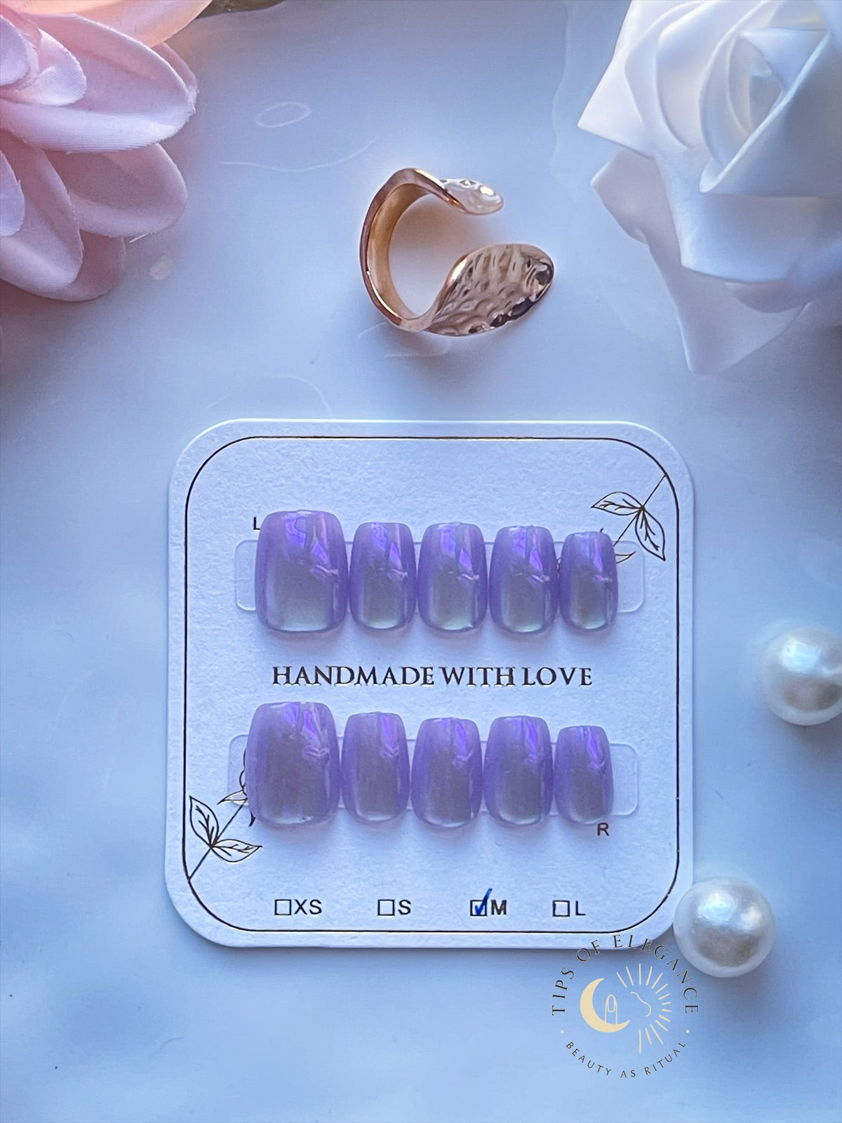 Petite lavender opal press-on nails with violet shimmer on a display card.
