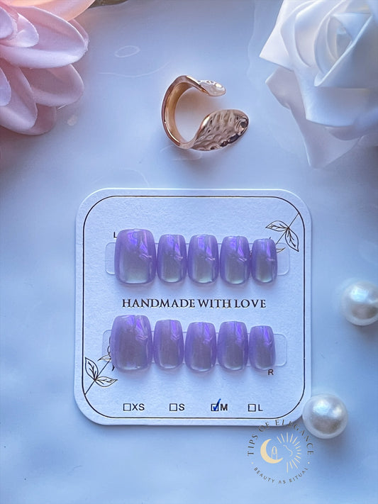 Petite lavender opal press-on nails with violet shimmer on a display card.

